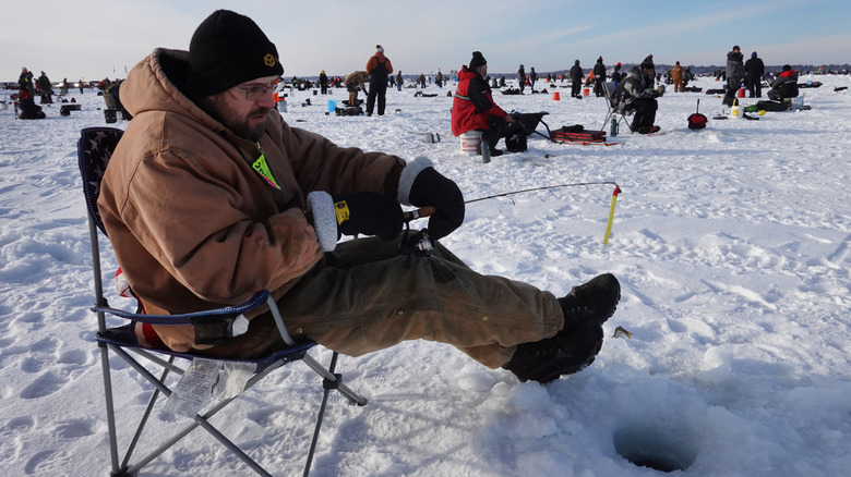 A man ice-fishing in Brainerd, Minnesota, in a snowy landscape