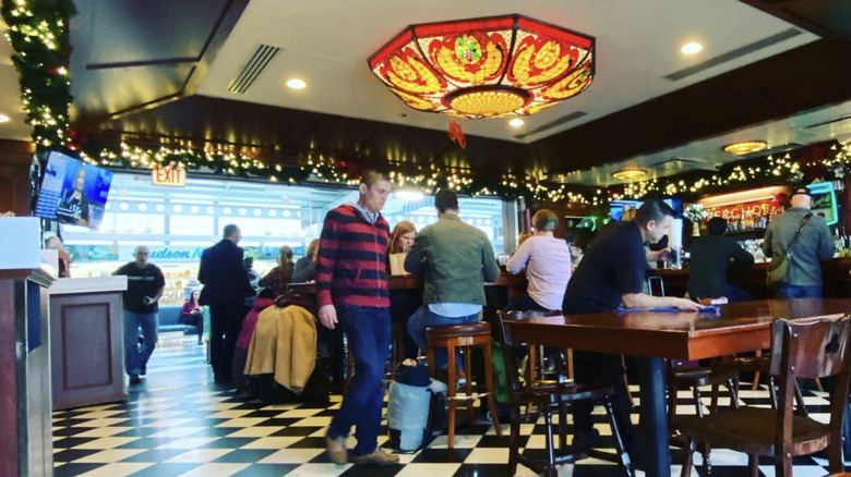 A musician plays saxaphone at Berghoff Cafe in O'Hare Airport as a woman in cowboy hat looks on