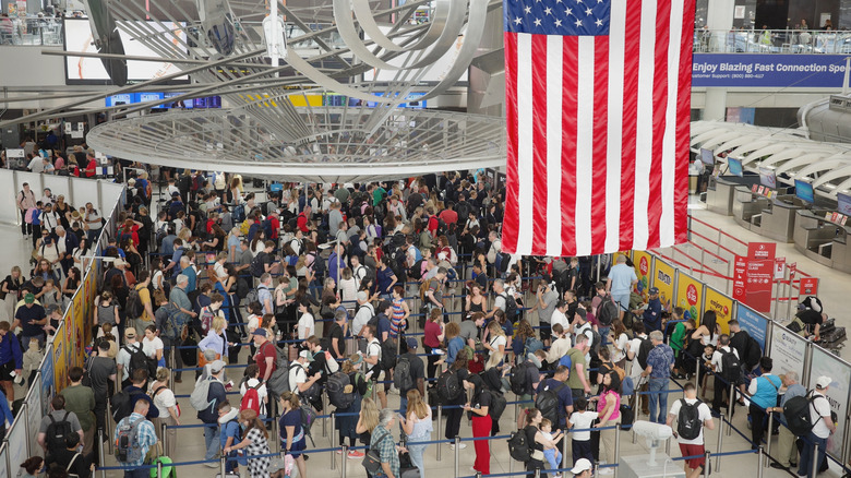 A crowd of people standing in a security line at JFK