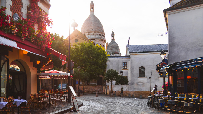 A cobblestone street with terrace seating in Montmartre, Paris