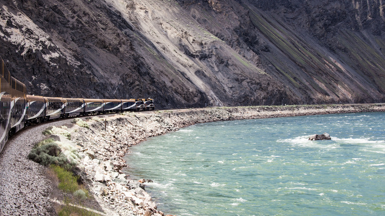 The Rocky Mountaineer train curves around the pale blue waters of Kamloops Lake.