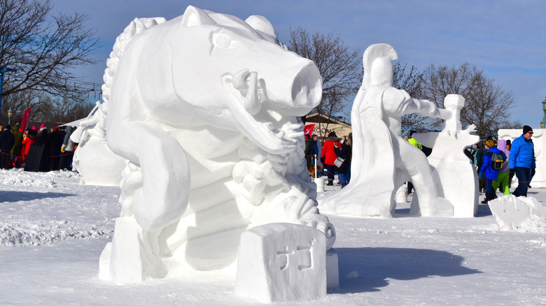 People gathered around snow sculptures at the Saint Paul Winter Carnival