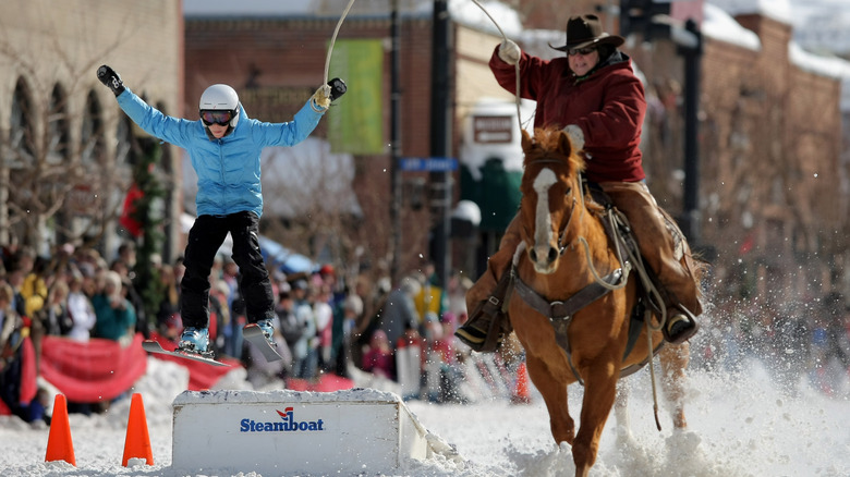 A skier pulled along the street by a horse at the Steamboat Spring Winter Carnival