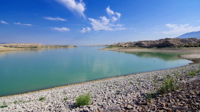 Rocky beach shore of Rye Patch Resevoir under a mostly blue sky