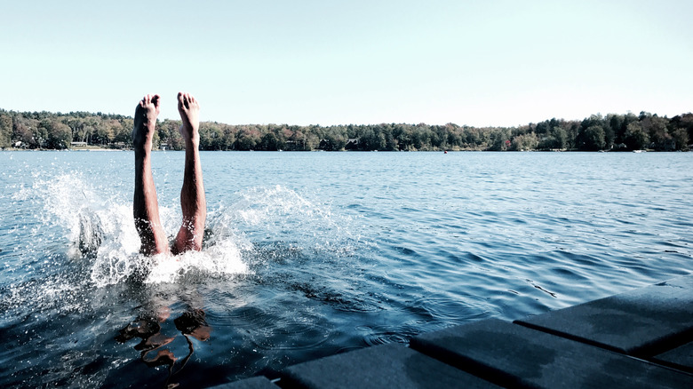 A swimmer plunges into the waters of a lake