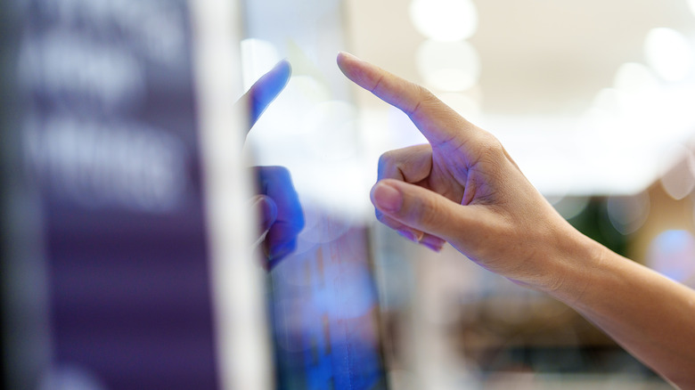 A finger about to touch a screen