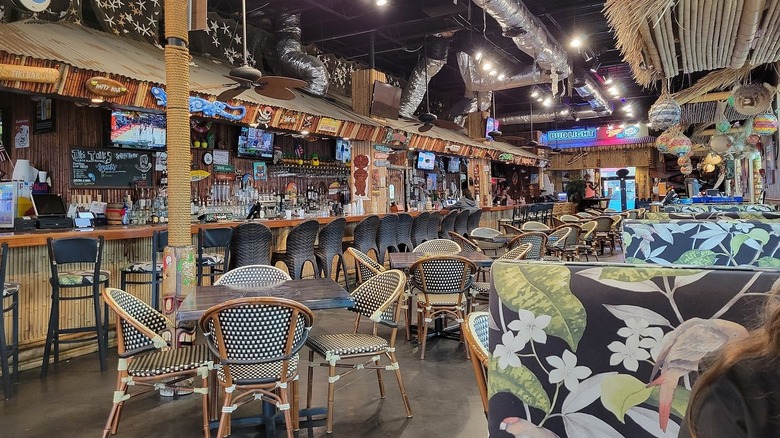 The interior of 8th Ave Tiki Bar & Grill, with tables and chairs along a bar