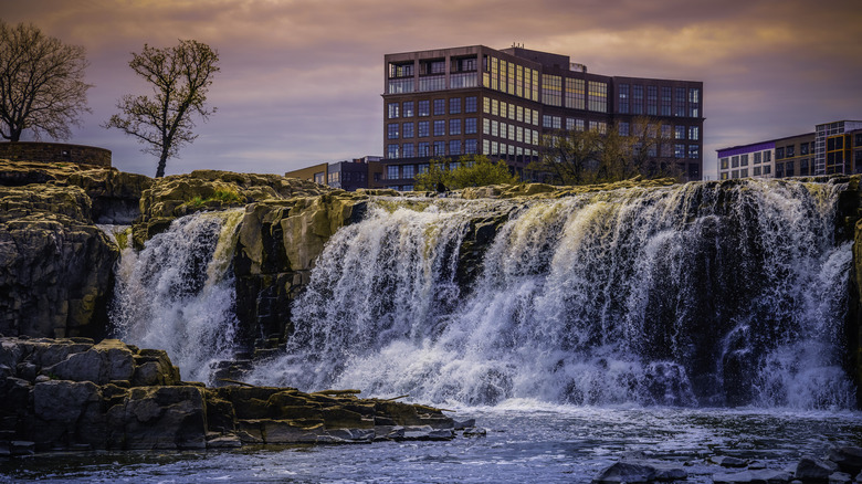 Glassy office building stands above raging waterfalls in Sioux Falls, South Dakota