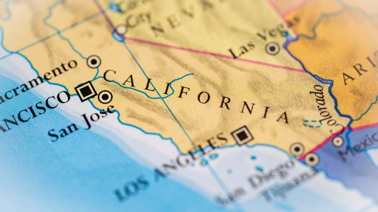 A paper map of California showing the state and some of its cities beside the ocean.