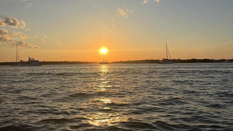 Sun setting over the water in Wrightsville Beach with boats on the water.