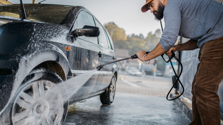 A young man washing his car
