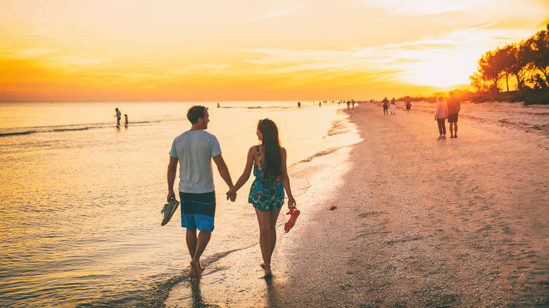 Couple holding hands on beach