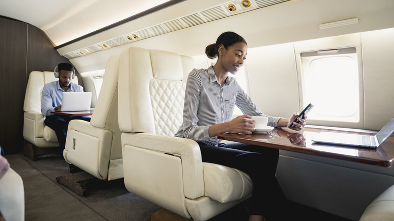 Young professionals in first-class plane seating