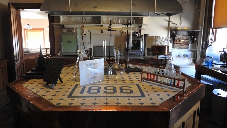 Room in the Indiana Medical History Museum, with test tubes on a tiled counter reading 1896 in the foreground and old medical equipment along the back wall