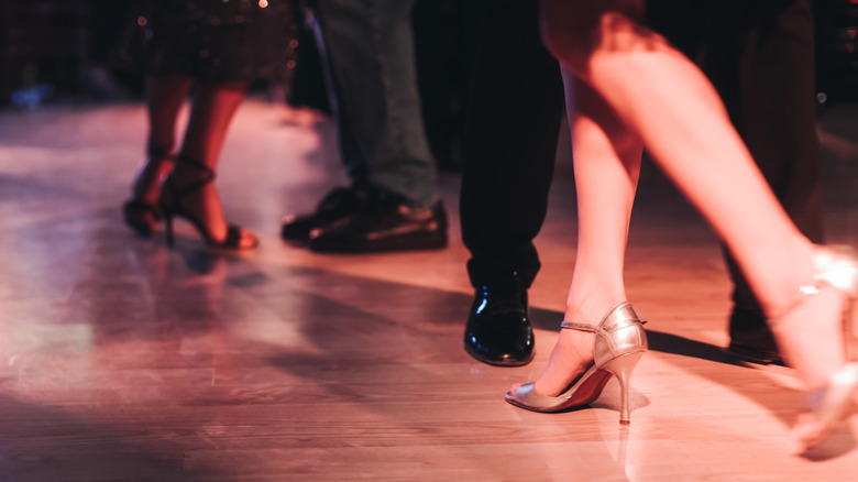 Dancers wearing heals and dress shoes dancing on a hardwood floor.