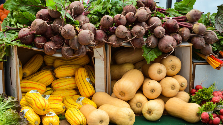 A farmers' market table display with butternut squash, beets, spaghetti squash, and chard in Sacramento.