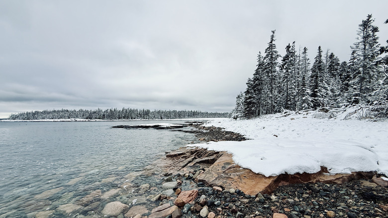Water laps snowy banks in Acadia National Park, Maine