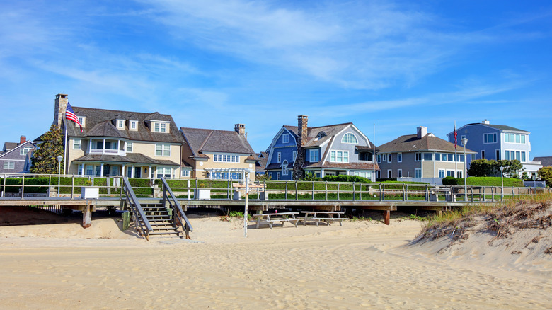 Beachfront homes in Sea Girt, with sand in the foreground under a blue sky