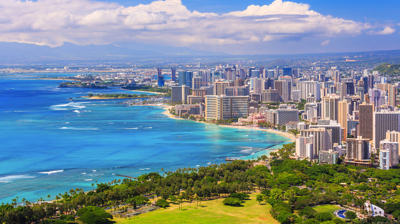 A bright aerial landscape shows the built-up coast of Honolulu, Hawaii