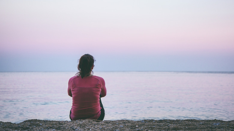 A lone woman sitting at the beach