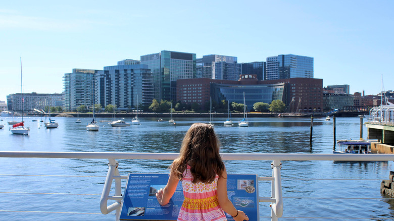 A young girl reading information outside Boston Harbor