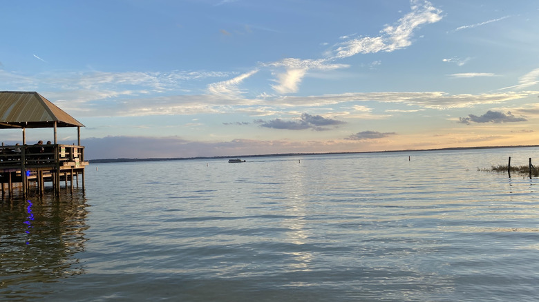 people sit on the edge of Lake Weir and enjoy the sunset reflecting off its clean waters