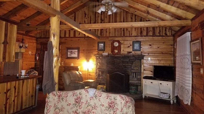 an old-fashioned wooden cabin with a stone fireplace in the Lazee Daze in the Ozarks resort