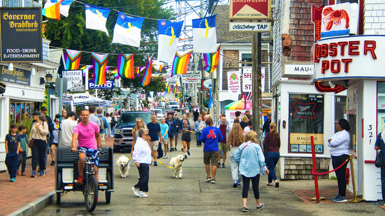 Summer day shot of banners hanging above people walking along a busy street in Provincetown, Massachusetts