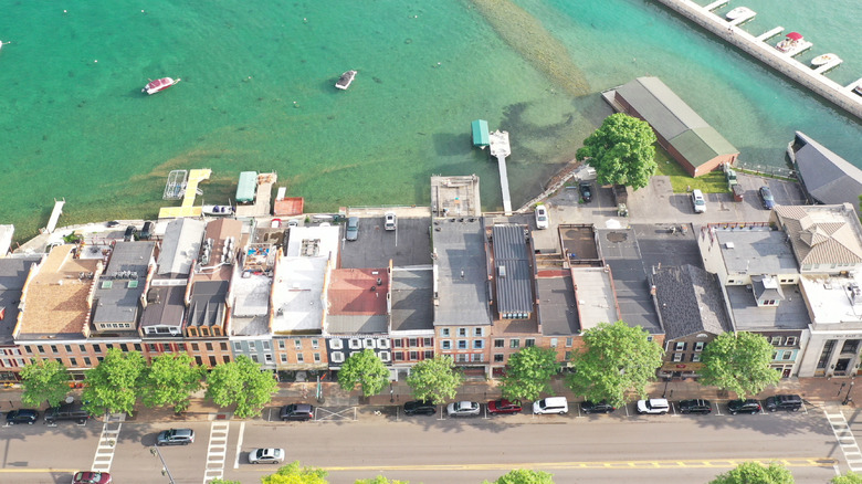 Top-down view of boats on a clear lake with a town with historic buildings in the foreground