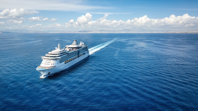 Aerial front view of a generic cruise ship sailing with speed over a calm ocean