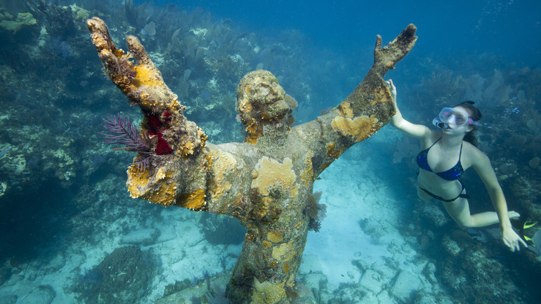 Snorkeler with Christ of the Abyss statue