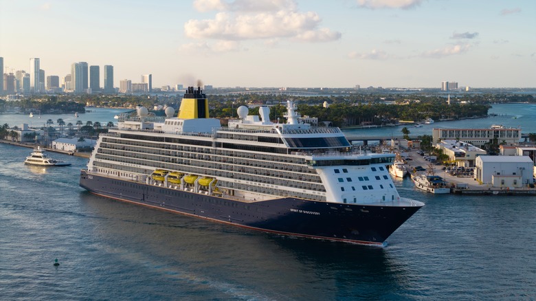 Saga's Spirit of Discovery cruise ship leaving port in Miami with the city skyline in the background