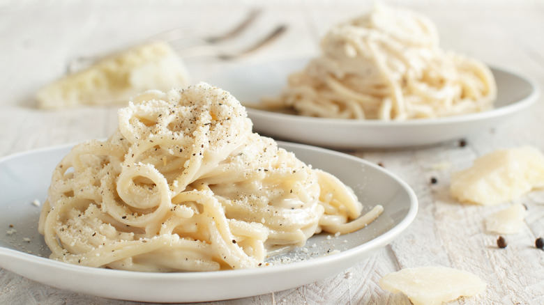 Plates of cacio e pepe on a white tablecloth