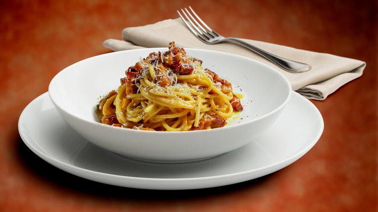 Plate of spaghetti carbonara on a wooden table