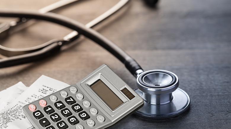 Stethoscope, calculator, and receipts on table