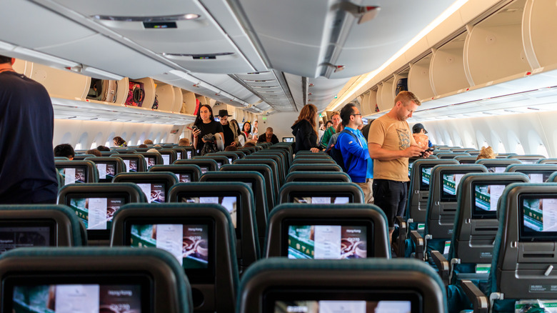 People boarding a Cathay Pacific flight in economy class at Schiphol Amsterdam Airport