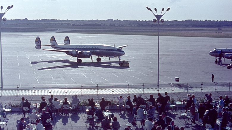 People on an outdoor terrace at an airport in Northern Germany in the 1960s