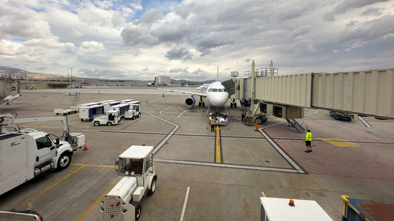 A plane and ground crew loading with a skybridge at Reno airport
