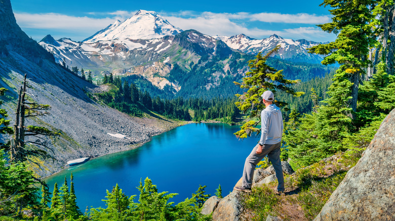 A hiker enjoys view of Mount Baker and Iceberg Lake on the Chain Lakes Loop trail.