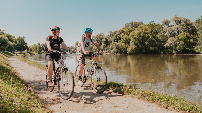 Two cyclists riding a path along the Mura river in Northern Croatia