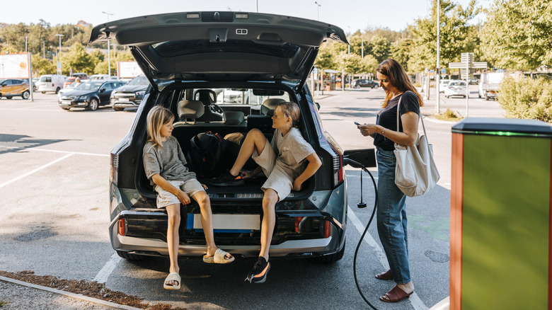 Woman and two children waiting for an EV to charge