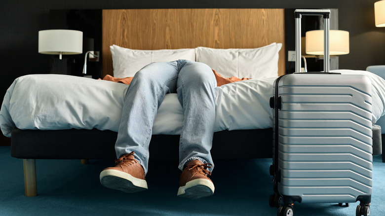 Man in sneakers on hotel bed