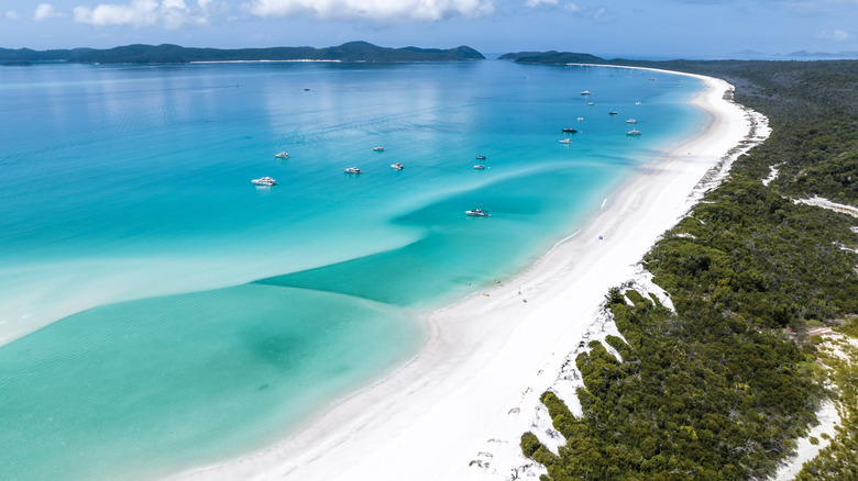 An aerial view of Whitehaven Beach with boats floating on the water