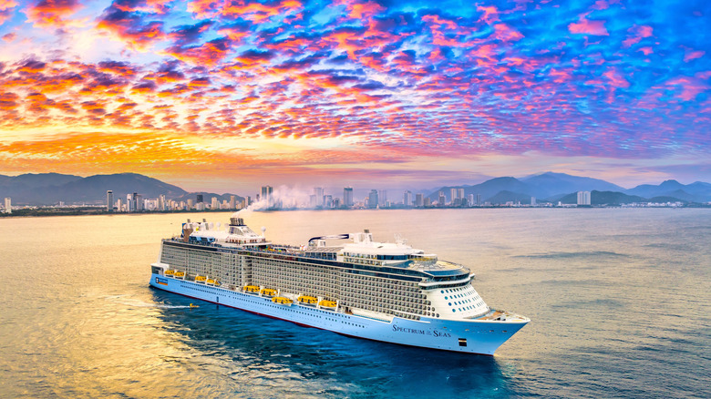 Luxury cruise ship sailing in harbor at sunset