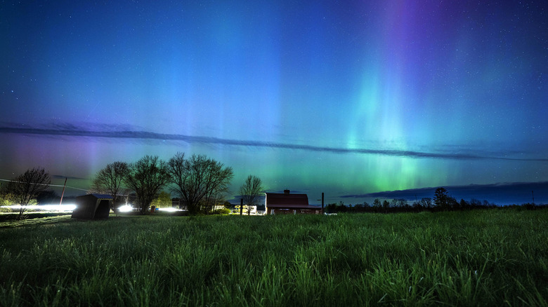 Northern Lights seen over a field and houses in Maine