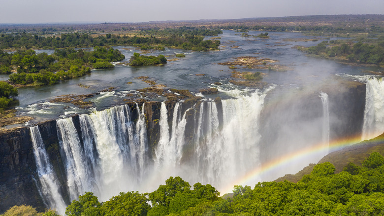 Aerial view of the massive Victoria Falls with a rainbow being cast over its waters