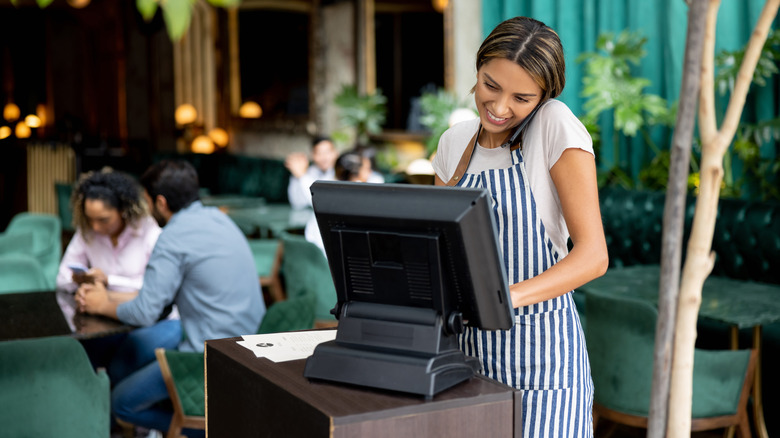 Restaurant hostess takes a reservation