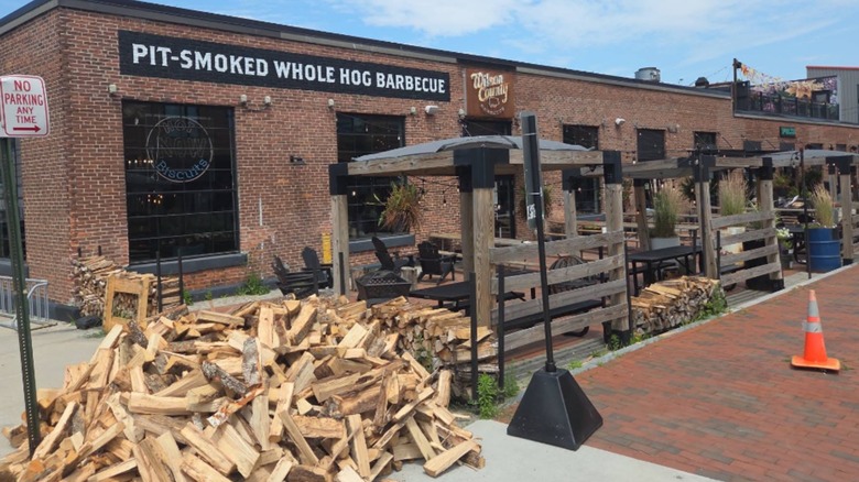 Exterior of Wilson County BBQ with pile of wood for smoking