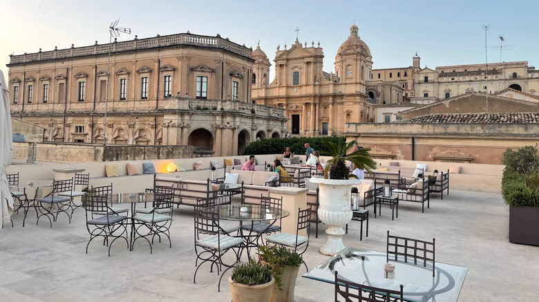 The rooftop bar of Gagliardi Hotel in Noto, Sicily, overlooking a church and other ornate buildings
