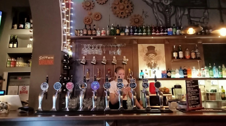 A bartender at Kalapinta Craft Beer pours beer from a tap